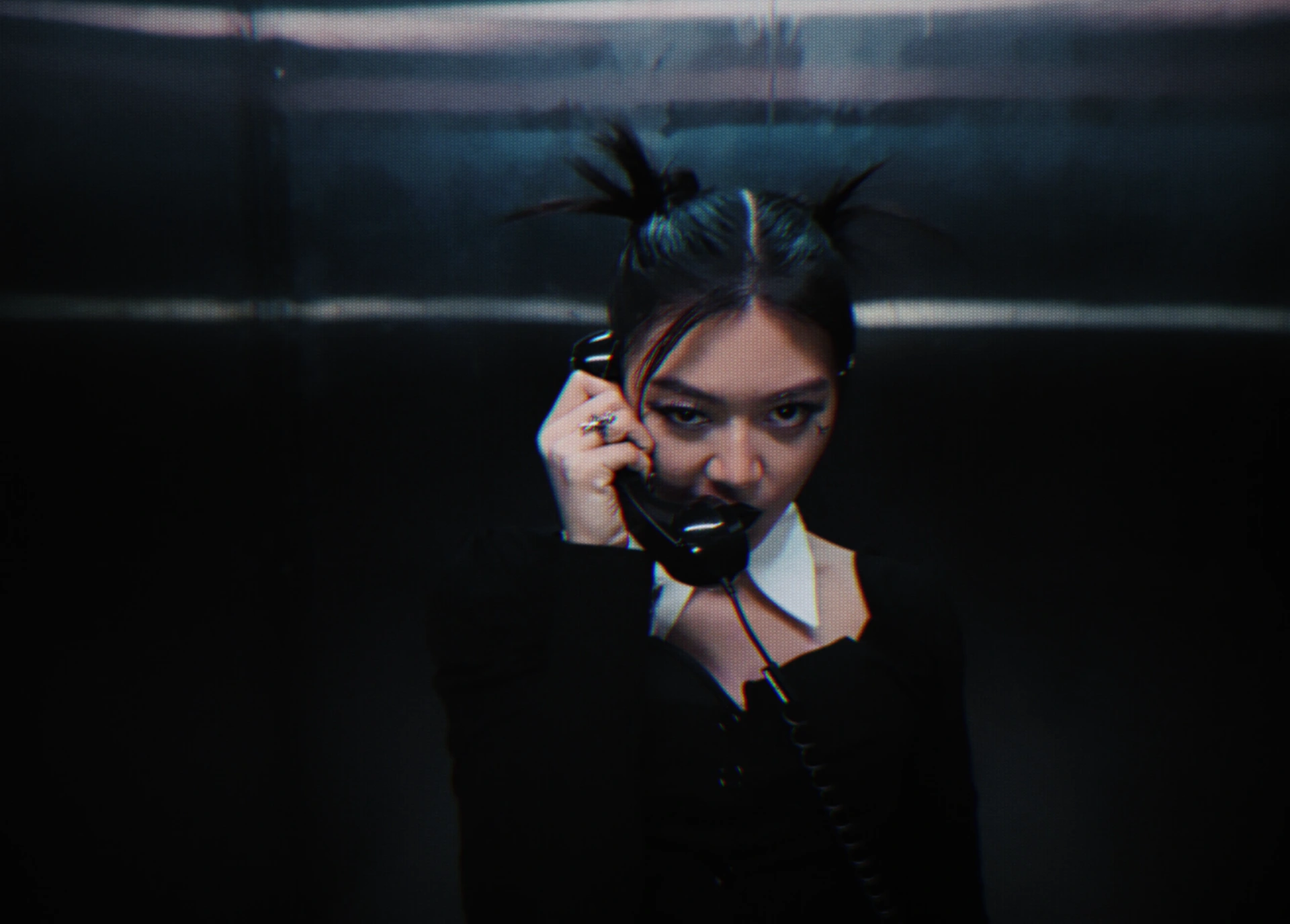 A close portrait of Jasmine Sokko holding a black telephone receiver.
