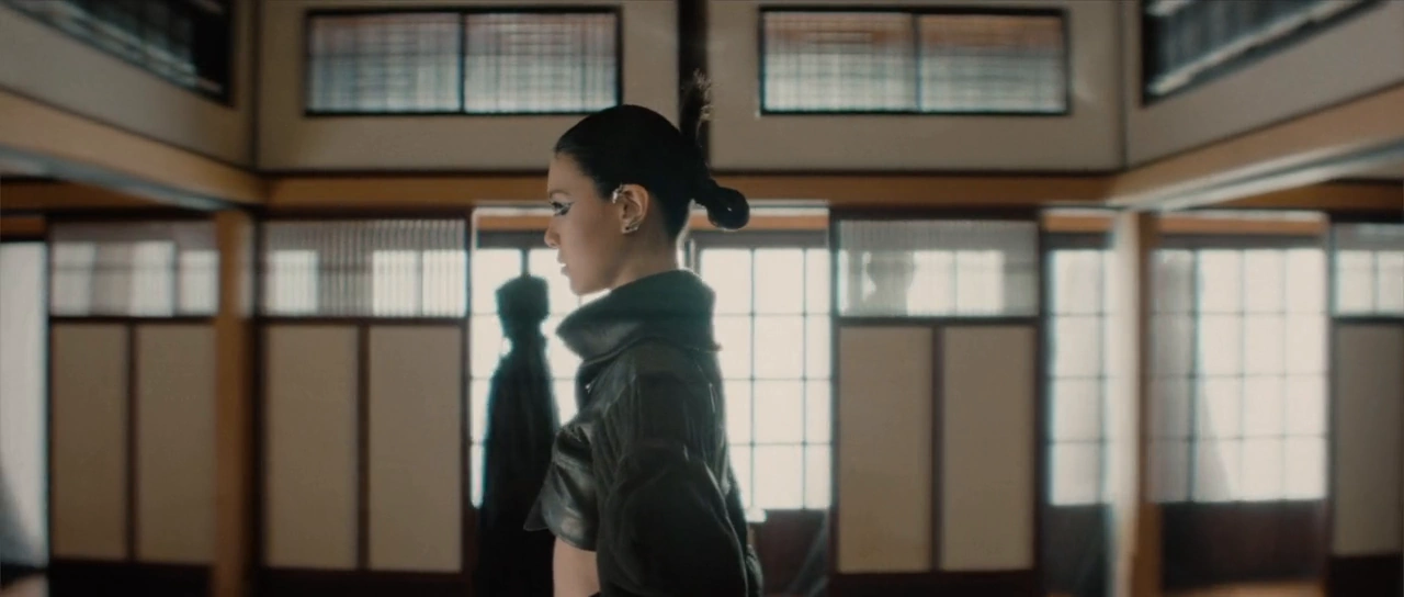 Jasmine Sokko performs beside shoji windows, then among flowers and painted screens.