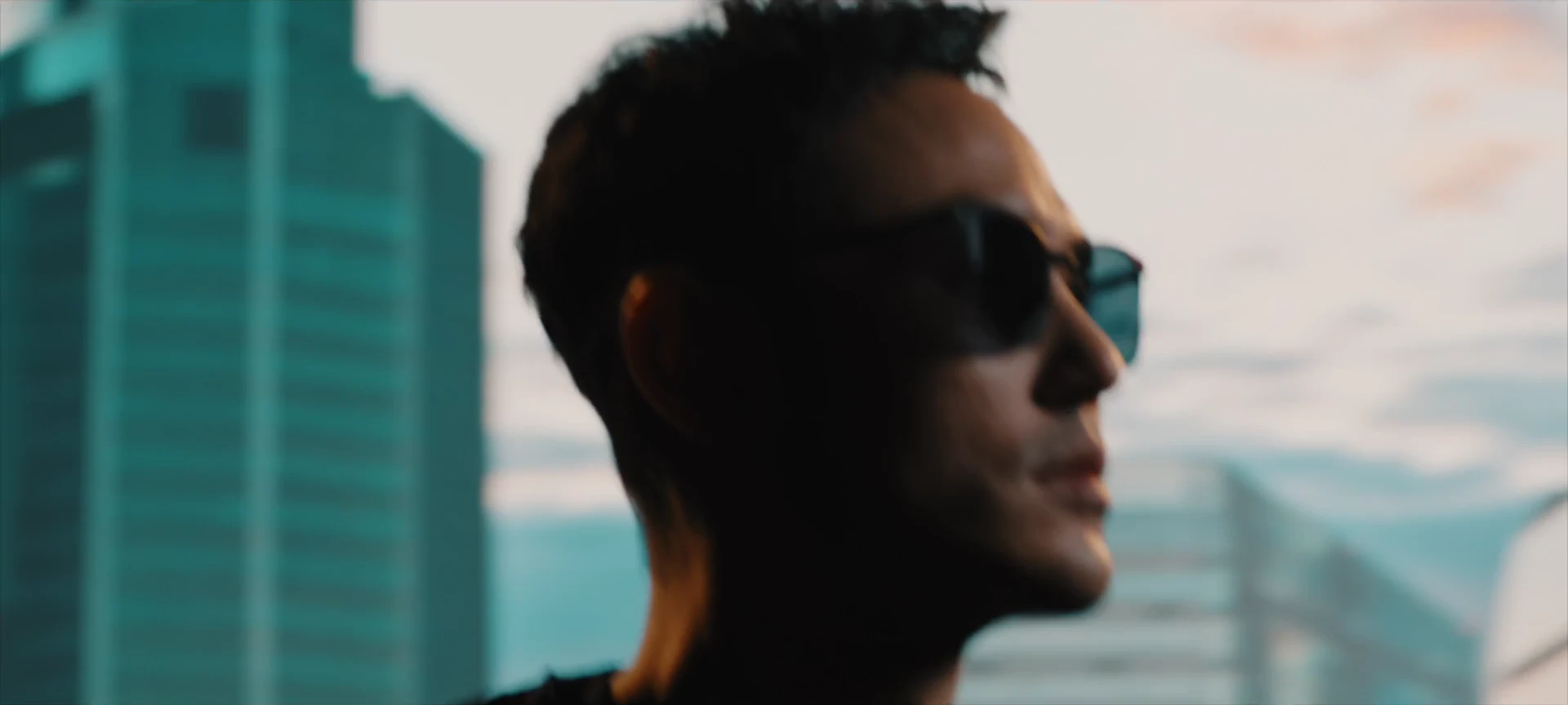 A sharply framed portrait of Ethan Juan with illuminated architecture behind him.