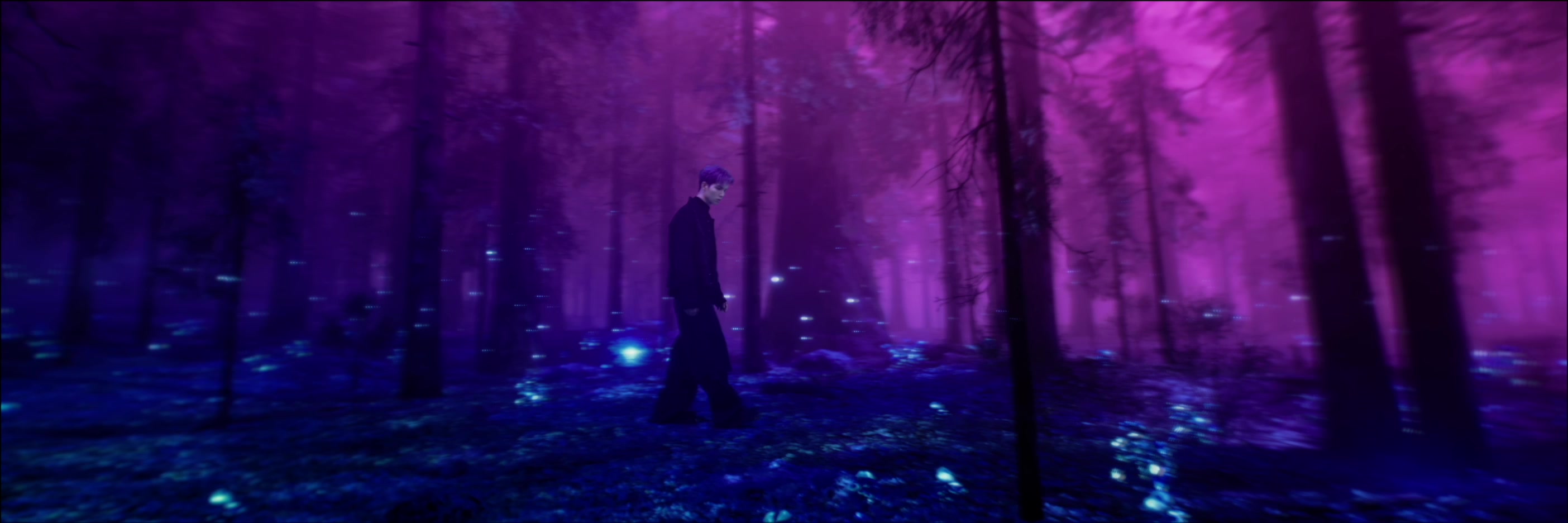 Patrick Brasca walks between trees and glowing blue plants in a violet forest.