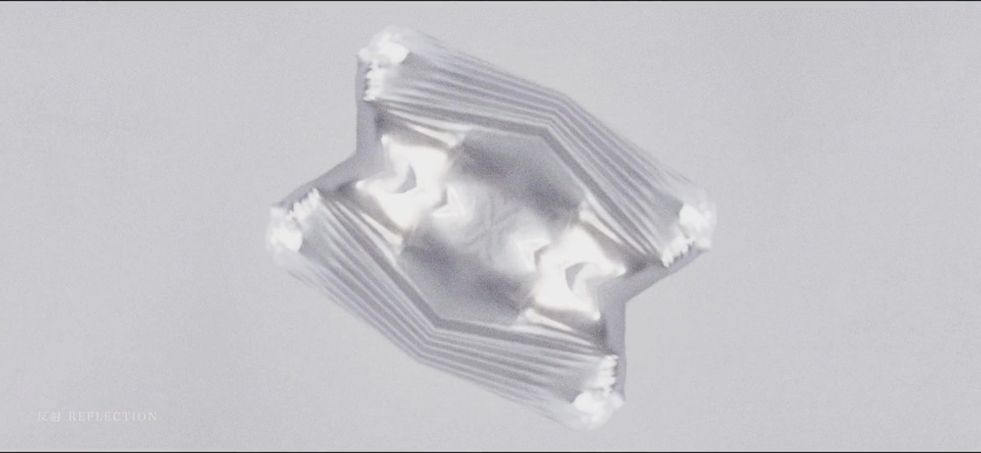 Floating reflective, layered geometric form on a pale background.