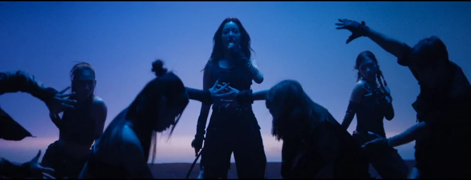 Dance silhouettes against blue and violet light.