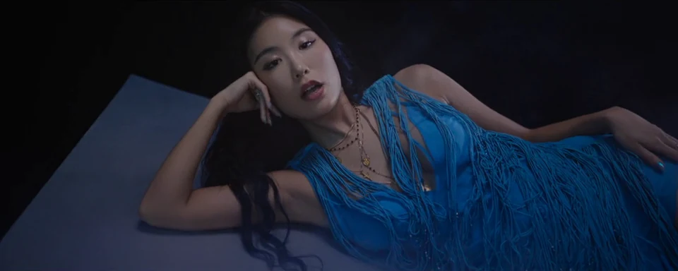 A reclining portrait in a sculpted blue dress.