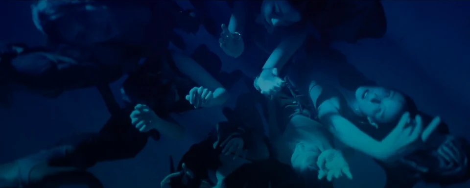 Overhead choreography in deep blue light.