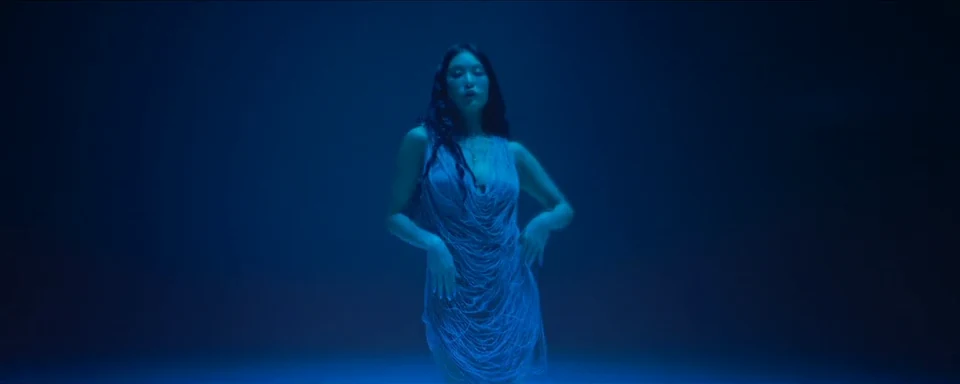 A solitary performance in a blue pool of light.