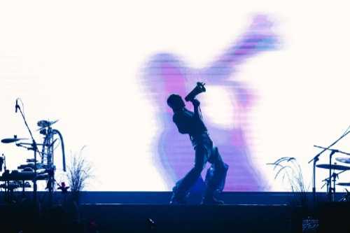 yellow dead or alive — Performer silhouetted against a bright screen