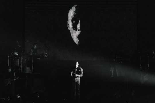 yellow dead or alive — Concert stage with a suspended face visual