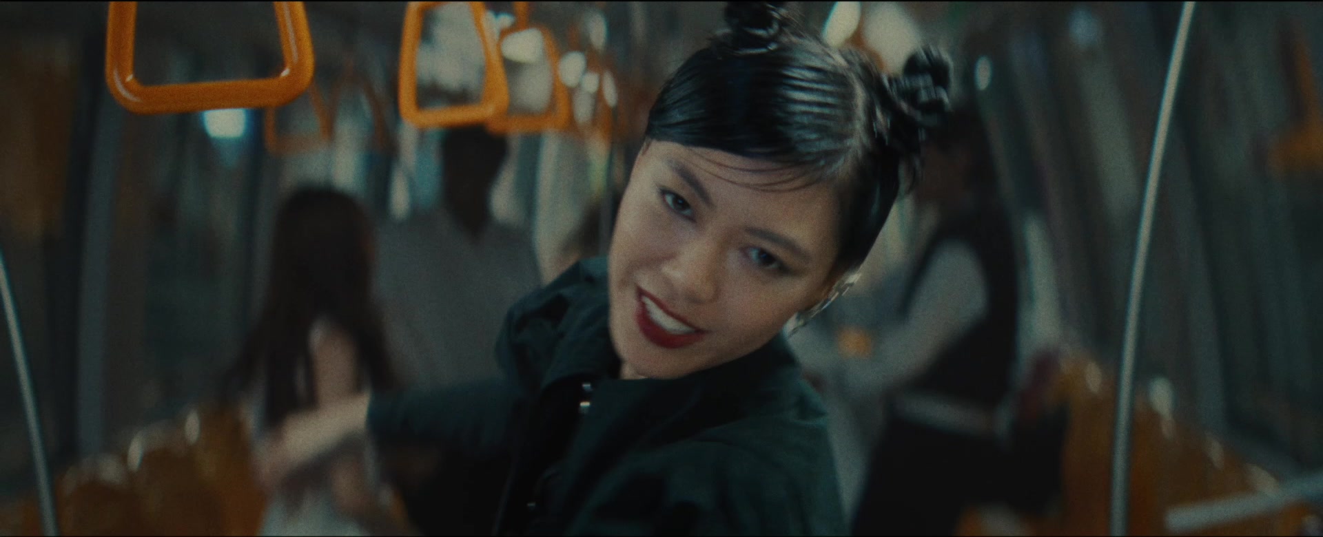 Jasmine Sokko in a train with orange hand grips